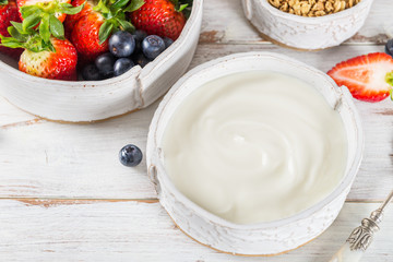 Bowl of natural yogurt with granola and fresh berries