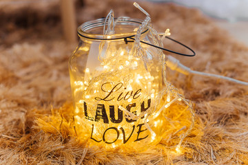 Glass jar with garlands in the room