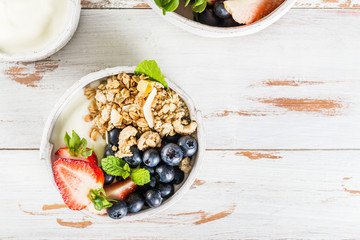 Bowl of natural yogurt with granola and fresh berries