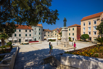 Traditional buildings around sunny square inside old town of Makarska, Croatia