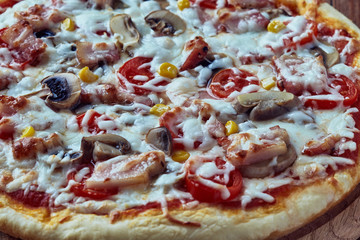 Homemade pizza milano, traditional italian pizza, tomato sauce, mozzarella cheese, bacon, mushrooms,