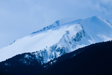 Plakat Mountain snow peak, beautiful natural winter backdrop. Ice top of the hill, blue sky background. Alpine landscape.
