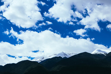 Fototapeta premium Mountain snow peak, beautiful natural winter backdrop. Ice top of the hill, blue sky background. Alpine landscape.