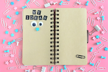 The notepad on the springs is open. Next to the stationery. On the brown pages of the notebook...
