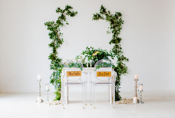 Decoration of the wedding table with flowers and branches in the botanical style for the bride and groom.