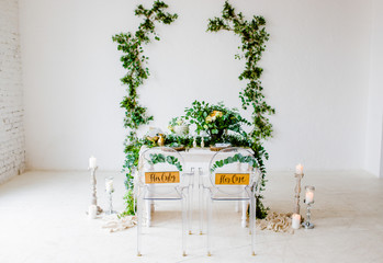 Decoration of the wedding table with flowers and branches in the botanical style for the bride and groom.