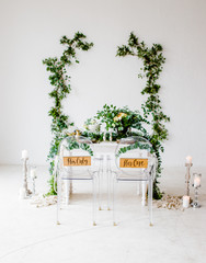 Wedding Banquet. Armchairs and table for newlyweds, served with cutlery and tableware with festive...