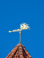 The weather vane on the roof of the tower.