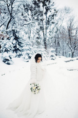 Portrait of an amazing bride. Bouquet, snow, winter.