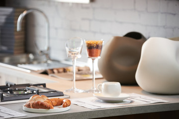 Delicious croissant and a two cup of coffee on a kitchen counter. Healthy breakfast with coffee in sunny morning for two person in modern kitchen interior