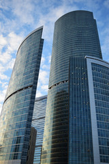 Low angle view of skyscrapers against blue cloudy sky. City landscape. Sunset.	
