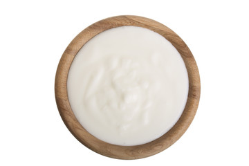 yogurt in a wooden bowl isolated on white background top view