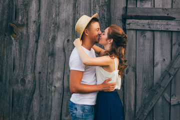 Beautiful guy and girl holding hands, kissing. Love story photo on outdoor in sunset light. Models. Couple in love. Pretty girl and brutal guy walking in outdoor. Shallow focus and some noise.