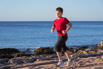 Yong boy running at coastline on morning exersises