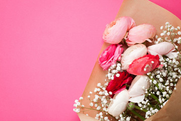 Pink and white ranunculus flowers on pink background. Flat lay in bright colors