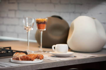 Delicious croissant and a two cup of coffee on a kitchen counter. Healthy breakfast with coffee in sunny morning for two person in modern kitchen interior