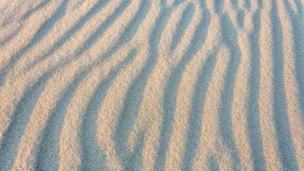 Wellen im Sand bei Gegenlicht