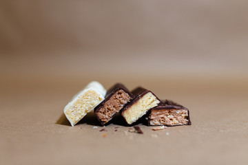 Four chocolate protein bars with different flavors in the context of sprinkle rice flakes on baking...
