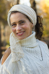 Portrait of good looking middle aged woman wearing white shawl on her head and turtle neck knitted...