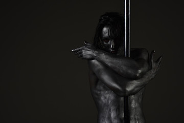 Fototapeta na wymiar Guy hugs metallic pole. Passionate dancer concept.