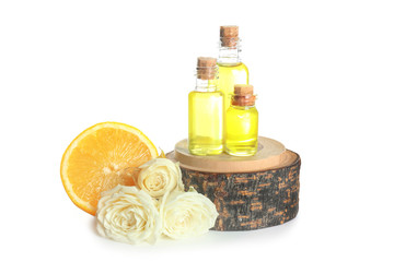 Bottles of perfume oil and flowers with lemon on white background