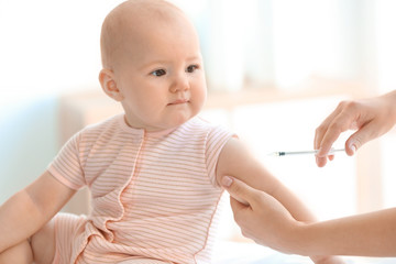 Doctor vaccinating baby in clinic