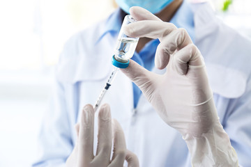 Female doctor with vial and syringe in hospital. Vaccination day