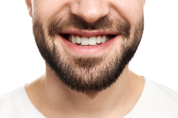 Obraz premium Young man with beautiful smile on white background. Teeth whitening