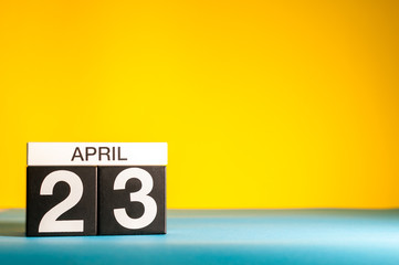 April 23rd. Day 23 of april month, calendar on table with yellow background. Spring time, empty space for text