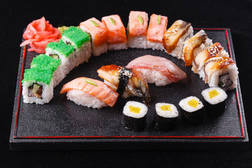 Japanese food, tasty of meal for lunch. Seafood. Sushi with eel, salmon, trout, tuna black background.