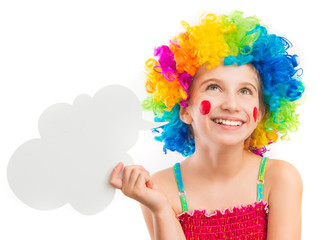 Lively little girl in bright colouful clown wig holding white speech bubble isolated on white background