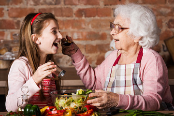 Granny gives to try a tasty vegetable salad to her grandchild