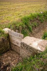 Scorcio di un fosso con chiusa in muratura e saracinesca in legno