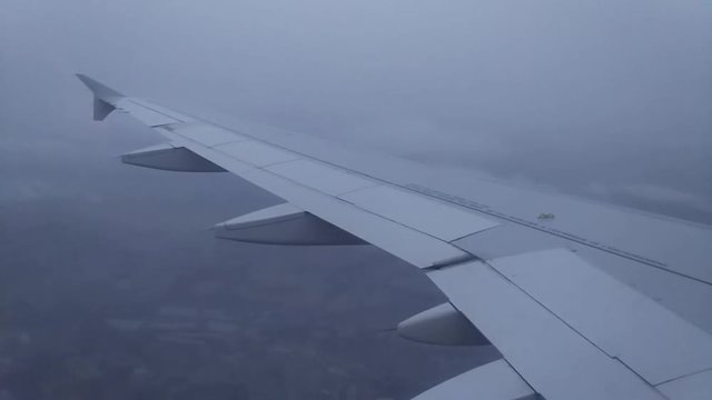 View from airplane window to the wing of an Airbus plane gradually descending to land in Paris, airport Charles de Gaulle