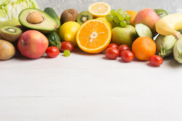 Fresh vegetables and fruits over white wooden background