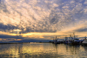 fishing boats and boats on the dock in the summer evening