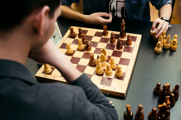 Pensive teenager play chess during chess competition in chess club. Education, chess and mind...