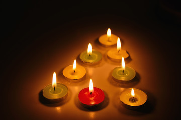 Multicolored lighted candles in the dark