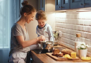 Foto auf Acrylglas  preparation of family breakfast. mother and child daughter cook porridge in morning © JenkoAtaman
