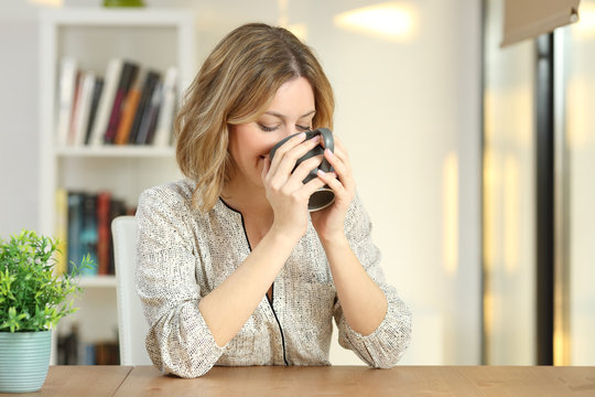 Woman drinking coffee from a mug at home
