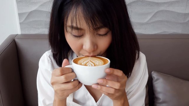 Asian woman drinking coffee with happy emotion. 
