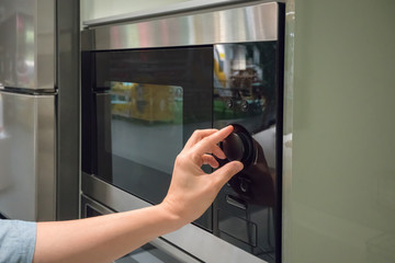 Woman's Hands adjusting timing button on microwave