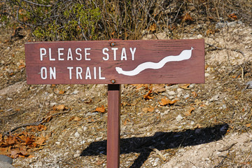 Sign warning hikers to stay on trail because of snakes at the Montezuma Castle National Monument cliff dwellings in Camp Verde, Arizona