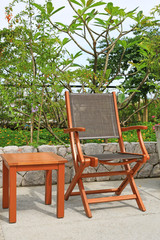 Wooden chairs set beside a pool.