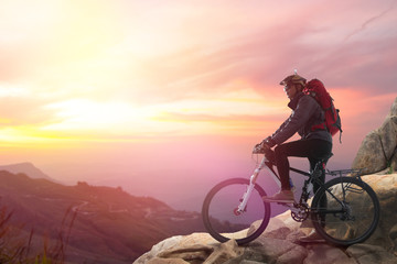 Obraz premium Biker riding on bicycle in mountains cyclist on the top of a hill