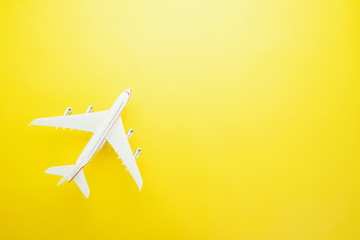 Flat lay design of travel concept with plane  on yellow background with copy space.
