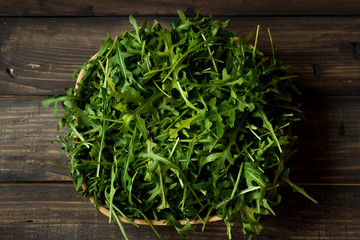 Fresh rucola with water droplets on a dark rustic background