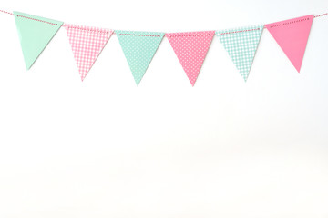 Obraz premium Colorful party flags hanging on white wall background, birthday, anniversary, celebrate event, festival greeting card background