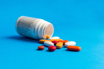 Assorted pharmaceutical medicine pills on blue background