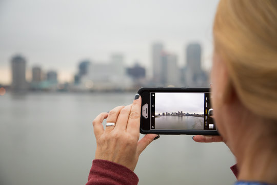 Woman Taking Pictures of The New Orleans Skyline with Her Smart Phone